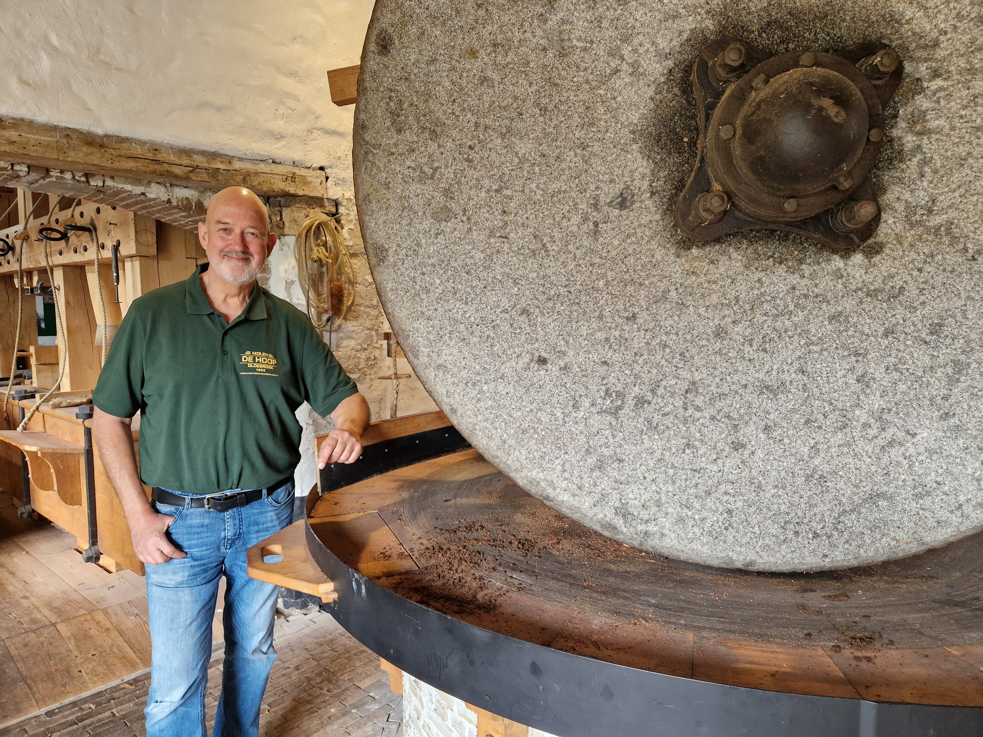 Molenaar Wim Timmerman bij de kantsteen die lijnzaad kneust.